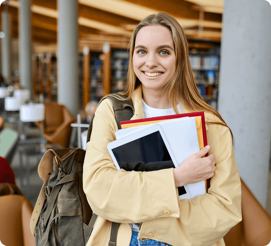 smiling teen, holding school notebooks, folders, and a pad.
