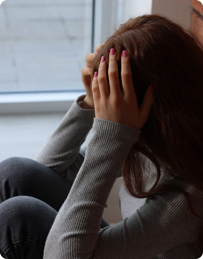 Girl on the floor, hands on head, potentially having suffered bullying or some type of victimization.