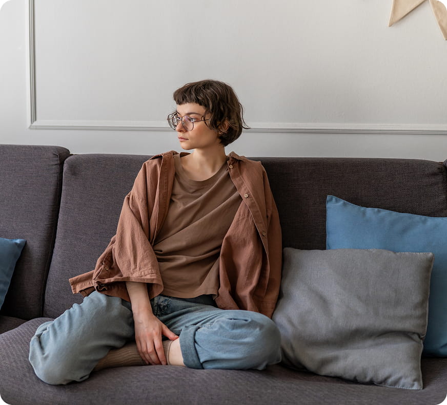 Girl sitting on the couch looking to the side longingly