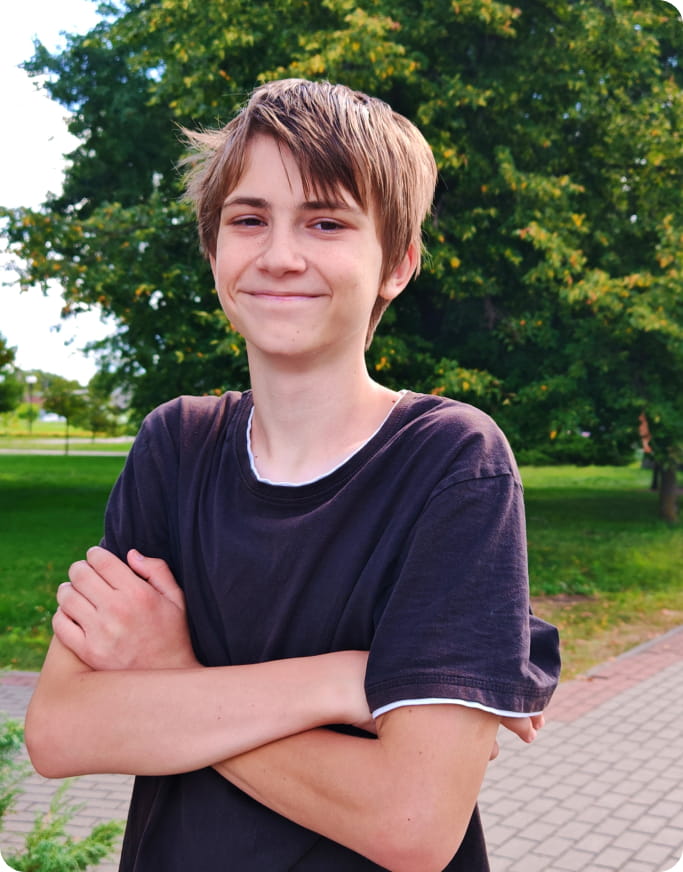 a boy smiling and crossing his arms
